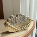 Metallische Muschel-Clutch, glänzende goldene Abendtasche mit Perlenhenkel, Vintage-Party-Handtasche. - Mit Perlenkette / Champagner