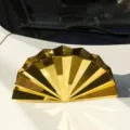 Dettaglio borsa pochette a ventaglio metallica dorata, design geometrico plissettato unico, stile chic. - Oro