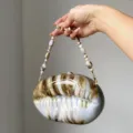 Exquisite acrylic shell evening bag featuring a gradient brown marbled design and beaded strap. - Camel