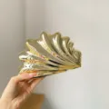 Vista dettagliata della pochette conchiglia dorata, borsa da sera in acrilico lucido. - placcatura in oro