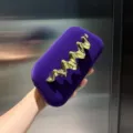 Elegante lila Samt Clutch Tasche mit einem auffallenden goldenen Wellen Metall Detail. - Dunkellila