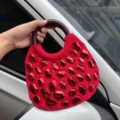 Rote Handtasche mit glänzenden Steinverzierungen und rundem Holzgriff für stilvolle Damen. - Rot