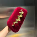 Red velvet box clutch bag with elegant golden metal wave detail, luxury fashion design. - Red