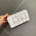 Detailansicht der weißen Marmor Acryl Clutch mit edler Hartschale und goldenem Verschluss. - Fluid Milchweiß
