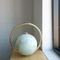 Marmoriertes kugelförmiges Abendtaschen Detail mit Metallringgriff für elegante Optik. - Fluid Smaragdgrün