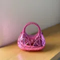 Nahaufnahme einer pinken metallischen geometrischen Acryl-Handtasche mit Dreiecksstruktur. - Fuchsia