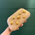 Acryl Clutch Detailansicht, einzigartiges goldenes Bohnen-Relief, stilvolles Accessoire nah - Gold
