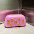 Detailansicht der rosa marmorierten Acryl-Clutch mit einzigartigen Goldklumpen. - Rosa