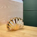 Goldene metallische Muschel-Clutch Detail, elegante Abendtasche, einzigartiges Acryl-Design. - Hautfarben