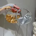 Primo piano della mini borsa da sera plissettata elegante con manico in cristallo. - Verde Fluorescente
