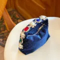 Detalle de primer plano del bolso de noche de terciopelo azul con perlas y cristales. - Azul