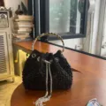 Schwarze Perlen-Eimerhandtasche mit silbernem Metallgriff und glitzernden Strassquasten. - Schwarz