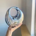 Glossy metallic swirl acrylic handbag detail, featuring a unique irregular ribbed design. - Silver
