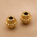Vue de detail de perles en acier inoxydable vintage avec rayures pour creation de bijoux. - Perle Tambour à Rayures Verticales / 7.4x7.3mm / Or