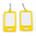 Detailaufnahme von gelben Plastik-Schlüsselanhängern mit Metallringen und Papiereinlage. - Gelb