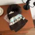 Primer plano de una bufanda de invierno de punto marrón oscuro con motivo floral blanco y azul - 160x22cm / Café