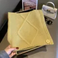 Vista detallada de bufanda de punto amarillo con rombos y botón, accesorio cálido y acogedor - 125x28cm / Amarillo Mostaza