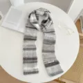 Detail shot of a retro knitted scarf featuring cozy grey and white gradient stripes. - Cream Color Scarf - Gray and White