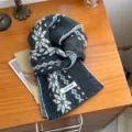 Acogedora bufanda de invierno de punto de lana gris oscuro con patrón de copo de nieve blanco. - Gris oscuro
