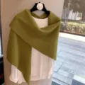 Detailed view of green knitted triangular shawl and white top, cozy winter texture. - Army Green