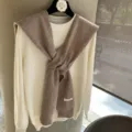 Gros plan détaillé du pull en tricot de laine doux associé à une écharpe élégante. - Mocha