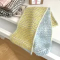 Vista detallada de la bufanda de invierno de punto grueso con diseño de corazón amarillo. - Amarillo