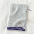 Bufanda de punto gris con borde morado de contraste y etiqueta de cuero FEIDE para invierno. - Gris claro