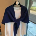 Vista detallada del panuelo triangular de punto calado azul oscuro con camisa blanca. - Azul