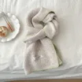 Bufanda de punto acogedora con borde verde contrastante y etiqueta artesanal para el invierno. - Mocha