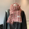 Detalle de primer plano de bufanda de punto de cuadros rojos y blancos con flecos y etiqueta. - Cuadros Rojos