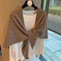 Close-up detail of the elegant solid brown knit triangular scarf shawl draped nicely. - Camel