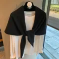 Toma detallada de bufanda triangular de punto negro con camiseta blanca en la percha - Negro