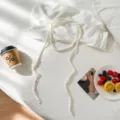 Detailed close-up view of a handmade white crochet choker scarf in aesthetic flat lay. - White
