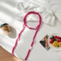 Primer plano del collar de ganchillo rosa hecho a mano y bufanda larga con textura de punto fino. - Rosa Fucsia