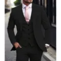 Close-up detail of a classic black three-piece suit paired with a pink tie and tie clip. - Black