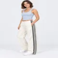 Vista dettagliata dei pantaloni della tuta larghi casual con eleganti strisce laterali nere. - Taglia S / Bianco