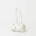 Detail view of retro white women bowling shoulder bag with dual handles and front pockets. - White