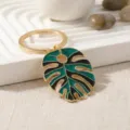 Gold metal monstera leaf keychain with green and black enamel finish, stylish accessory. - Green