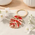 Gold metal keychain with red pink enamel monstera leaf pendant, tropical bag charm accessory. - Red