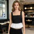 Elegante top sin mangas en blanco y negro con contraste y dobladillo de volante plisado. - S / Tops / Negro