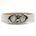 Detailed view of a chic white leather belt featuring a unique silver crescent cross-star buckle. - White