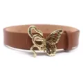 Close-up view of the exquisite gold snake and butterfly buckle on a brown leather belt. - Gold Clasp / Camel