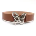 Detailed view of fashionable brown leather belt with unique silver snake butterfly buckle. - Silver Clasp / Camel