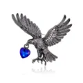 Detaillierte Nahaufnahme einer schwarzen Metall-Adler-Broche mit blauem Kristall-Herz. - Waffenschwarz Adler Beißt Blaues Herz (C962-C)