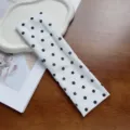 Close-up detail of white elastic wide headband featuring elegant black polka dot print design - 7cm Polka Dot Headband - White