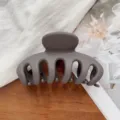 Matte grijze haarklem minimalistische haarklauw detailshot met duidelijke textuur en structuur. - Mat Donkerbruin