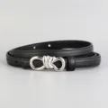 Detail view of black leather belt with silver tone knot buckle, minimalist style. - Black
