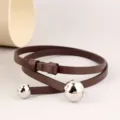 Detailansicht eines minimalistischen braunen Ledergürtels mit polierten silbernen Kugenden. - 100cm / Kaffeebraun