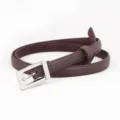 Close-up of women's dark brown slim leather belt with silver square buckle detail. - Coffee