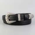 Detailed close-up of a black leather women belt with vintage silver western engraved metal buckle. - Black